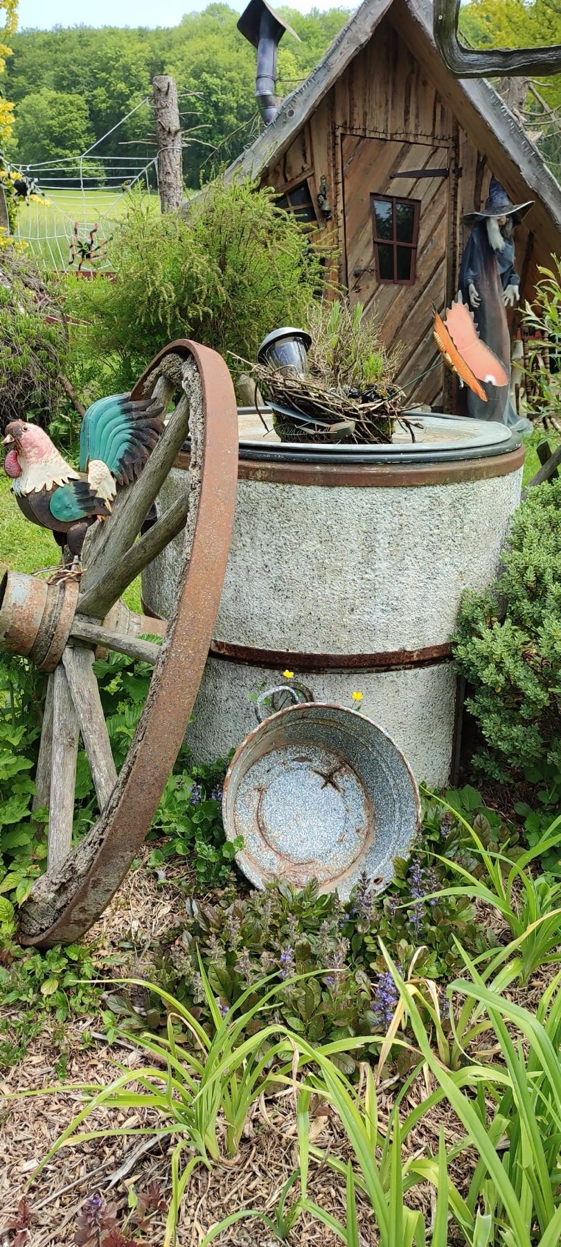 Gartenecke mit altem Wagenrad und Hexenfigur