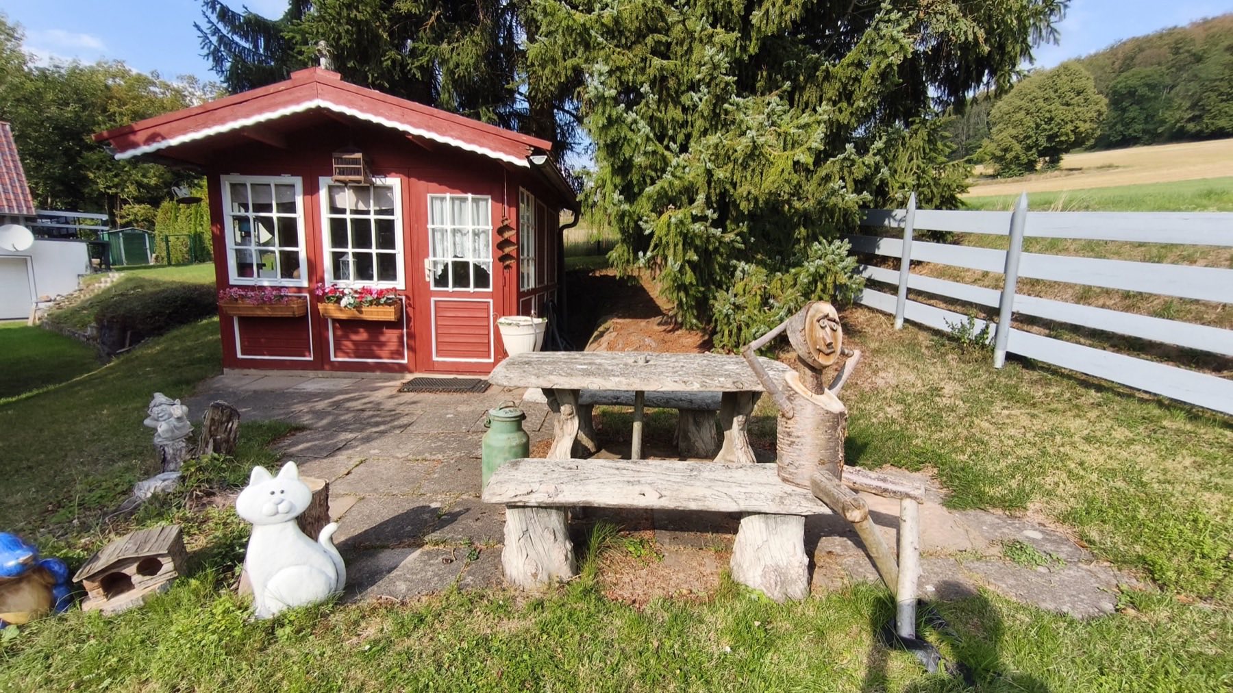 Rotes Gartenhaus mit Sitzgruppe